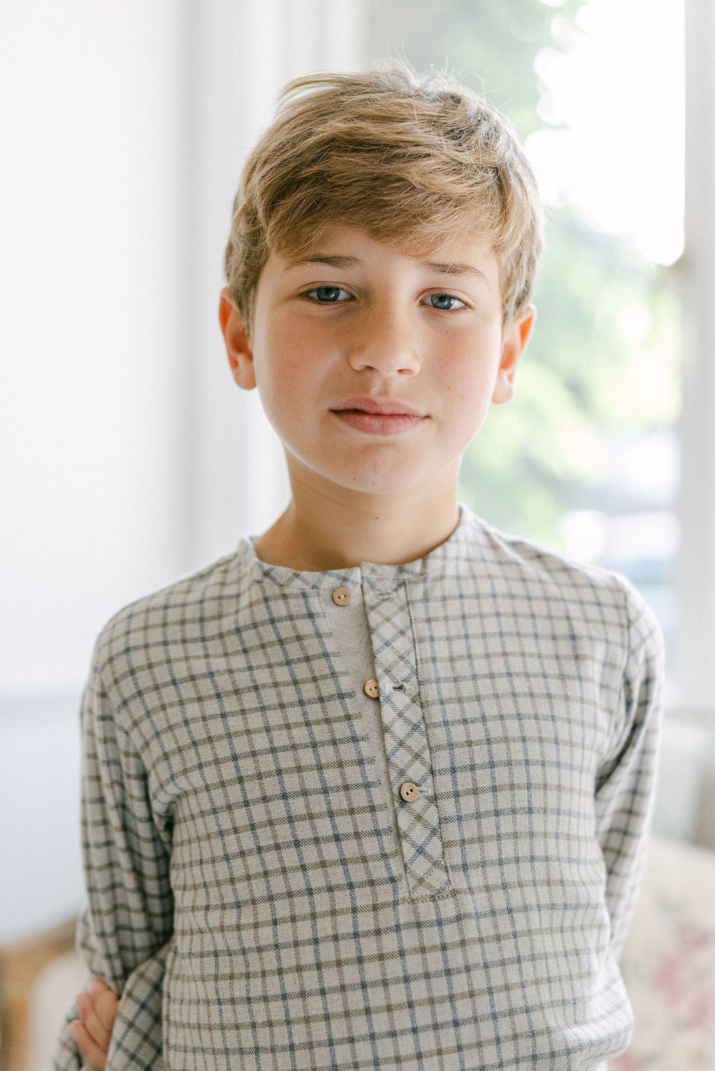 Young boy wearing a checkered shirt with a blurred background