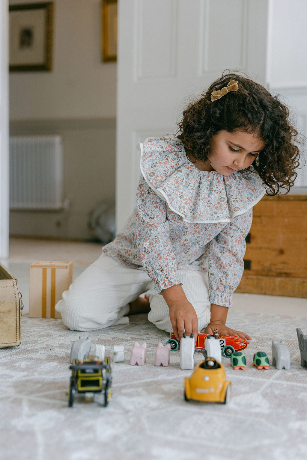 Child playing with toys on a carpeted floor in a home setting